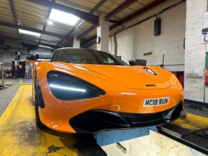 McLaren sports inside MRC Limited automotive garage Sleek McLaren supercar front view, inside MRC Limited garage.